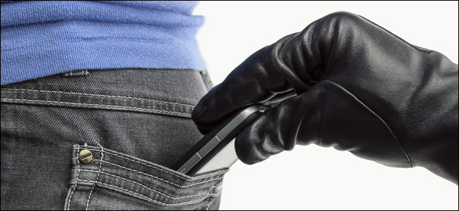 Una mano enguantada robando un teléfono del bolsillo trasero de alguien.
