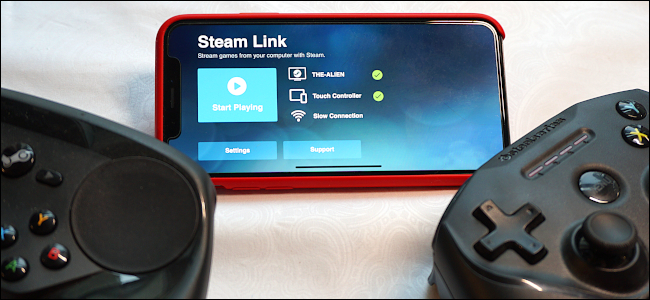 Steam Link en un iPhone junto a un controlador de videojuegos.