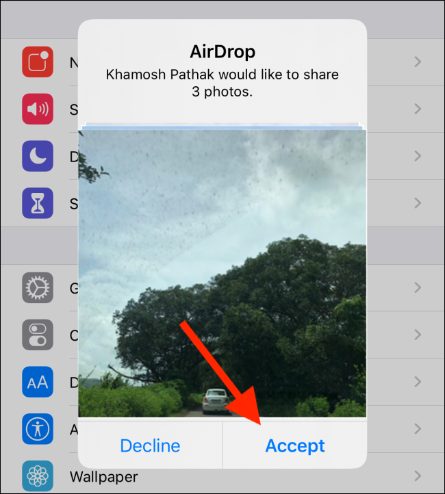 Una solicitud de AirDrop para compartir fotos;  su contacto tiene que tocar "Aceptar" para iniciar la transferencia del archivo.