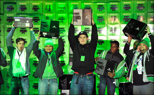 Varios usuarios de Microsoft sosteniendo nuevas consolas Xbox One el día del lanzamiento