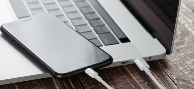 Un iPhone conectado a una MacBook con un cable Lightning a USB-C.