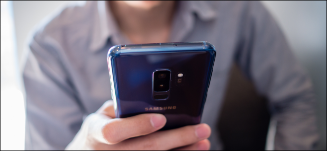 Hombre sujetando un teléfono Android azul