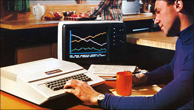 Un hombre en un escritorio escribiendo en el gran teclado Apple II en un anuncio de 1977.