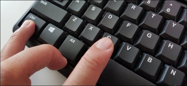 Dedos presionando Ctrl + C para copiar texto en un teclado de PC.