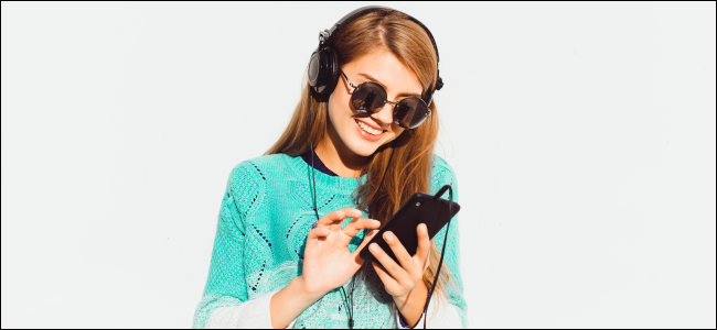 Mujer usando audífonos y tocando en un iPhone