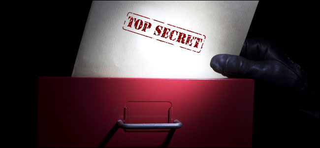 Una mano sacando un documento marcado como "Top Secret" de un archivador.