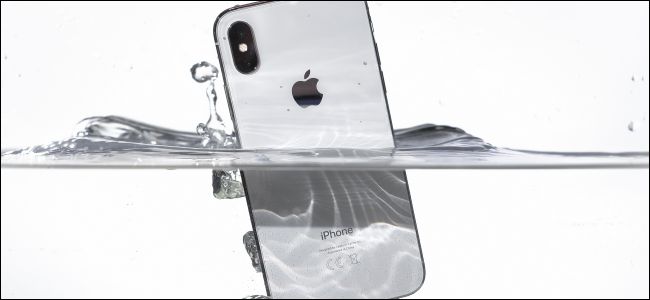 Sumergir un iPhone X plateado bajo el agua.