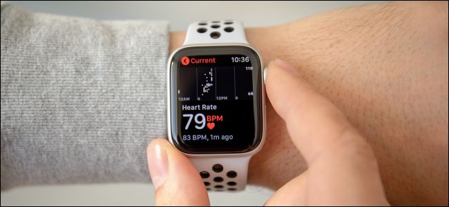 La mano de un hombre revisando el monitor de frecuencia cardíaca en un Apple Watch Series 4.