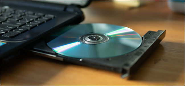 Un CD en la bandeja de la unidad de DVD-R de una computadora portátil.