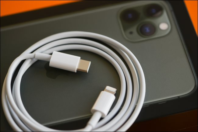 Un cable de carga rápida Lightning a USB-C que descansa sobre un iPhone 11.