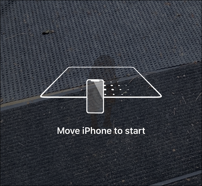 Un teléfono escaneando el suelo para cargar la experiencia de RA.