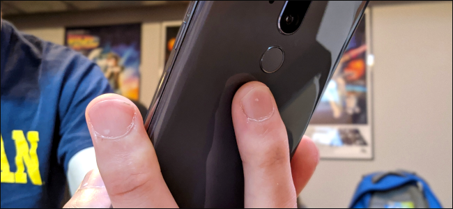 Los dedos de alguien en la parte posterior de un teléfono Android.