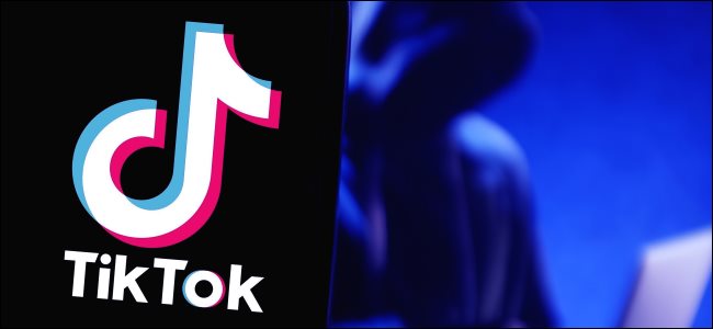 Un logotipo de TikTok en un teléfono con una figura usando una computadora portátil en el fondo.