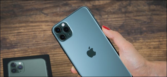 Una mano sujetando un iPhone 11 Max Pro y luciendo la parte trasera con la cámara.