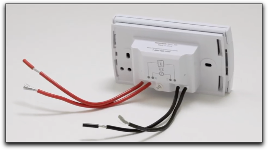 Un termostato de alto voltaje típico con 2-4 cables negros y rojos.