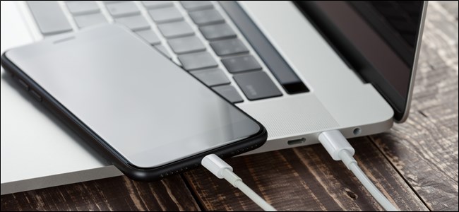 Un iPhone conectado a una MacBook para restaurarlo manualmente.