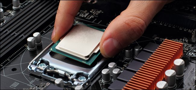 Una mano conectando una CPU a un zócalo en una placa base.