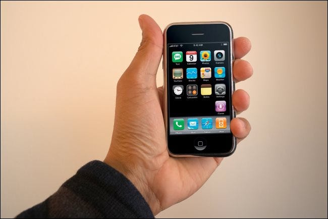 Una mano que sostiene un iPhone de primera generación.