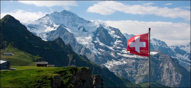 Bandera suiza ondeando frente a una montaña