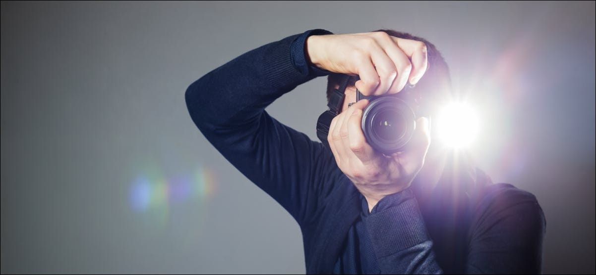 Un hombre toma una foto con una cámara con flash incorporado.