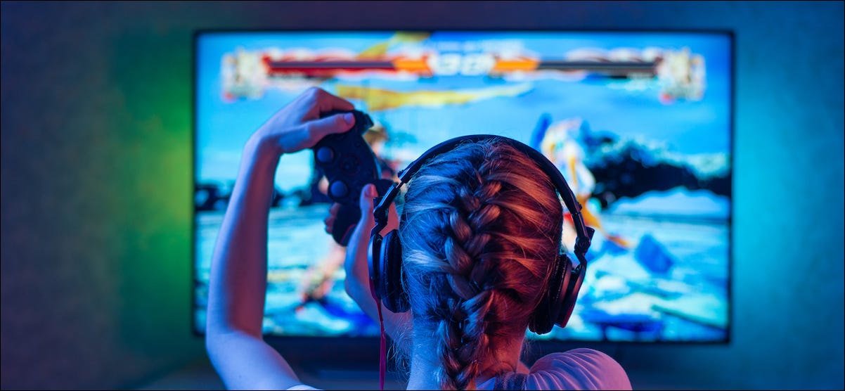 Persona jugando videojuegos en un televisor con iluminación de fondo