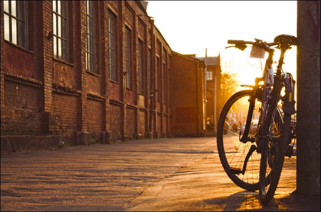 Una bicicleta estacionada en una acera de la ciudad al atardecer.