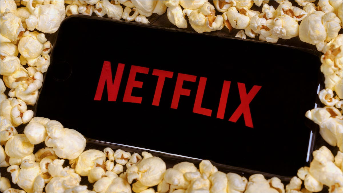 El logotipo de Netflix en un teléfono inteligente sentado sobre una pila de palomitas de maíz