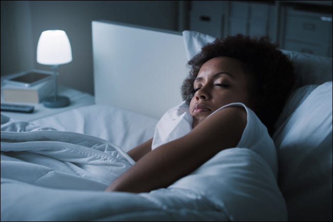 Una mujer durmiendo en su cama por la noche.