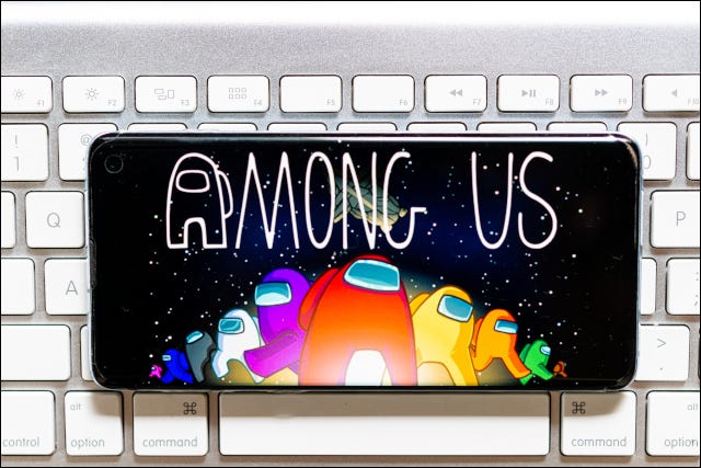 Un teléfono inteligente en la parte superior de un teclado con la pantalla de título Among Us