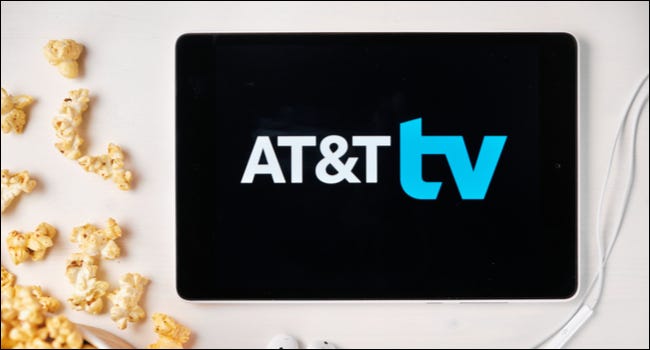 Logotipo de AT&T TV en una tableta junto a palomitas de maíz derramadas