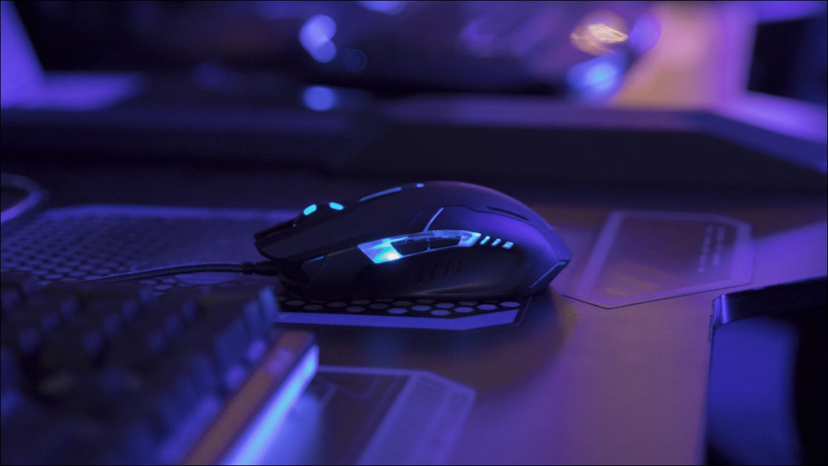 Encendido del mouse para juegos en el escritorio de la computadora en luz azul