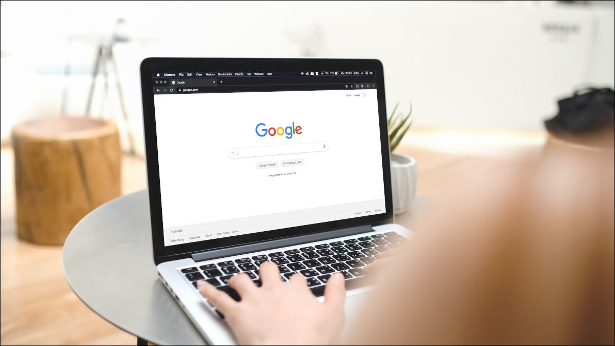 Mujer escribiendo en un portátil con la búsqueda de Google abierta en el navegador
