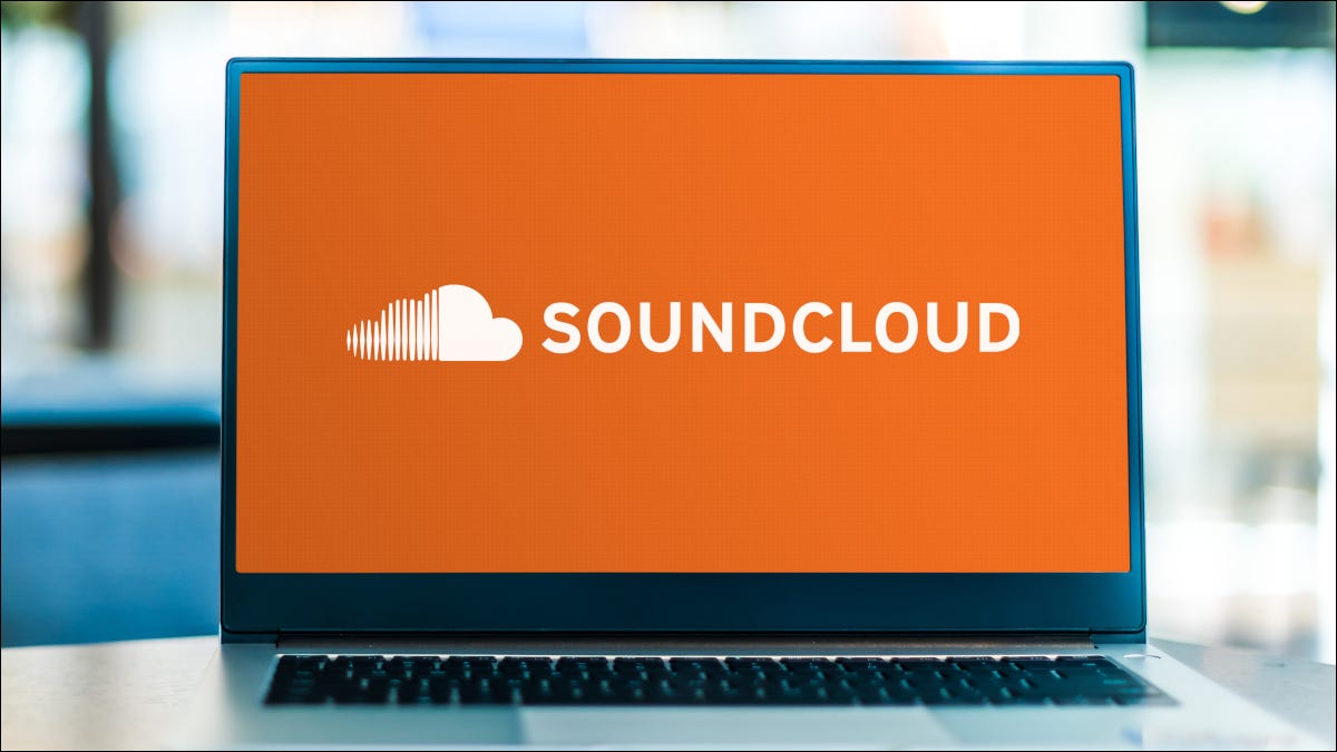 Portátil abierto que muestra el logotipo de Soundcloud sobre un fondo naranja