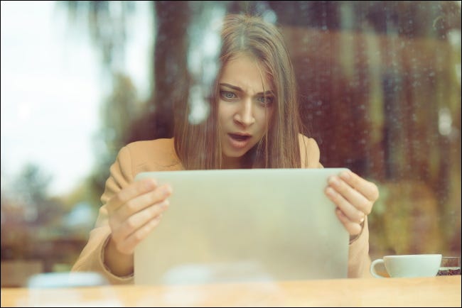 Mujer con una expresión de asombro mirando la pantalla del portátil