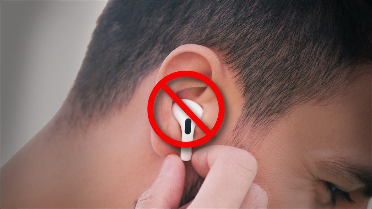 Persona que sostiene un Apple Airpod tachado en una oreja.