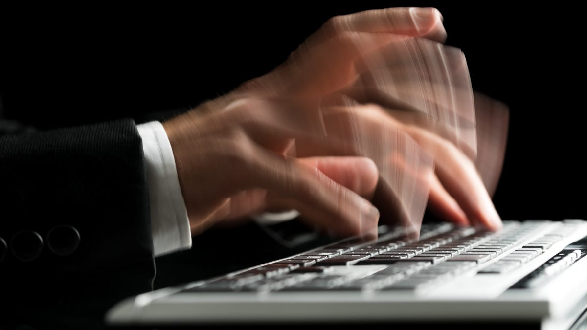 Cerca de manos escribiendo rápido en un teclado de computadora