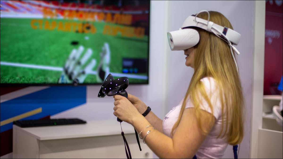 Una mujer jugando en un visor de realidad virtual de Windows Mixed Reality.