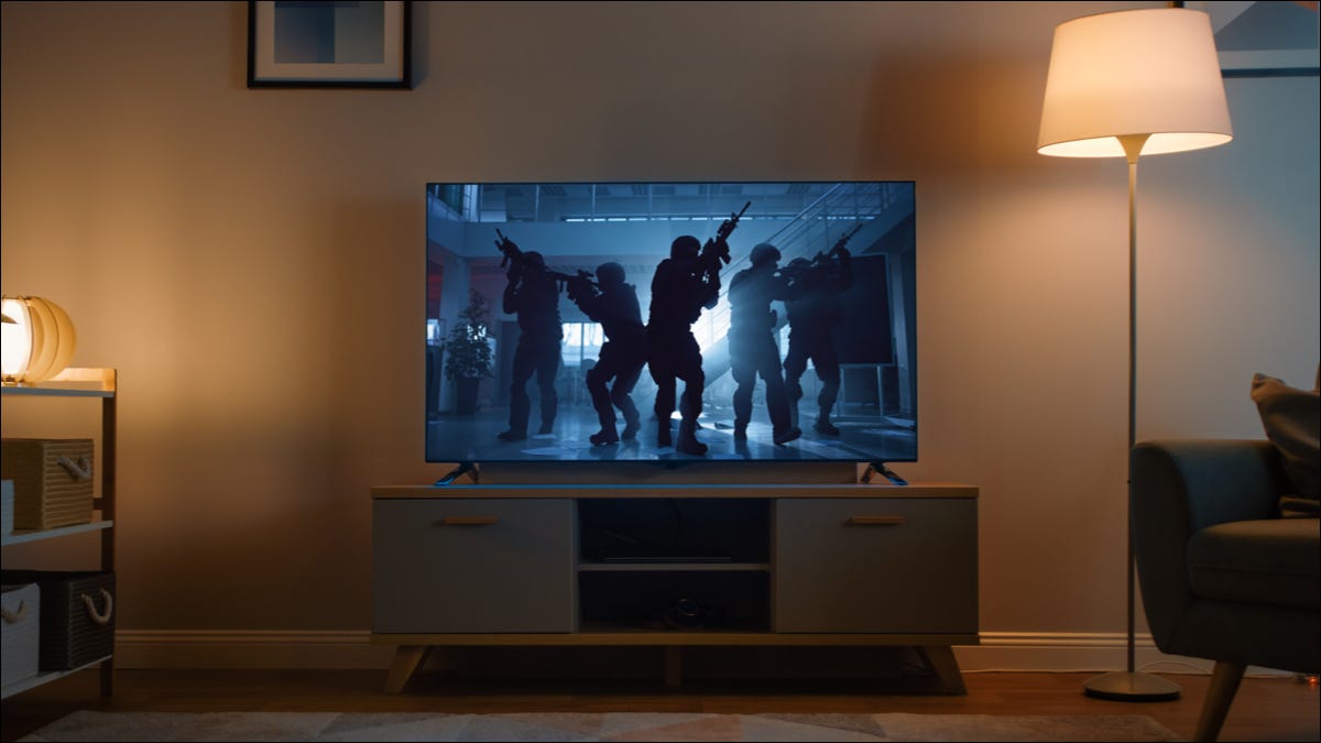 Ein Fernseher, der in einem Wohnzimmer einen düsteren Actionfilm zeigt.