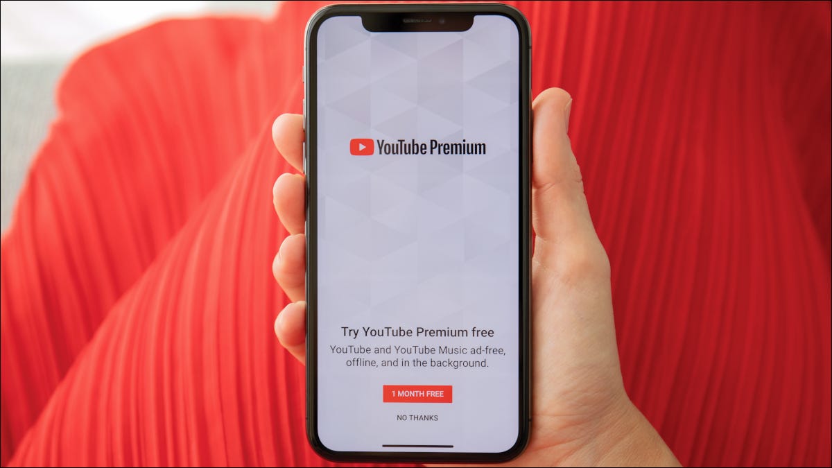 Mano que sostiene el teléfono inteligente que muestra la página de registro de YouTube Premium