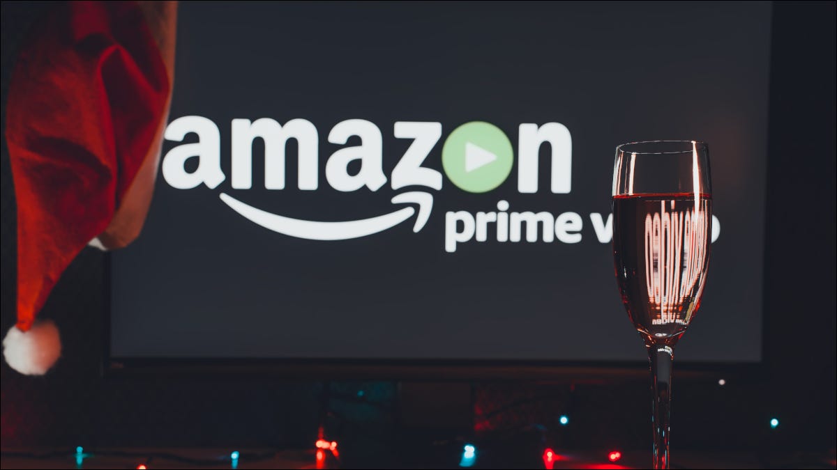 Logotipo de Amazon Prime Video en un televisor con un gorro de Papá Noel detrás de una copa de vino