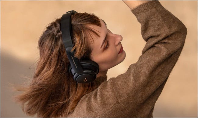 Mujer escuchando música con auriculares Anker