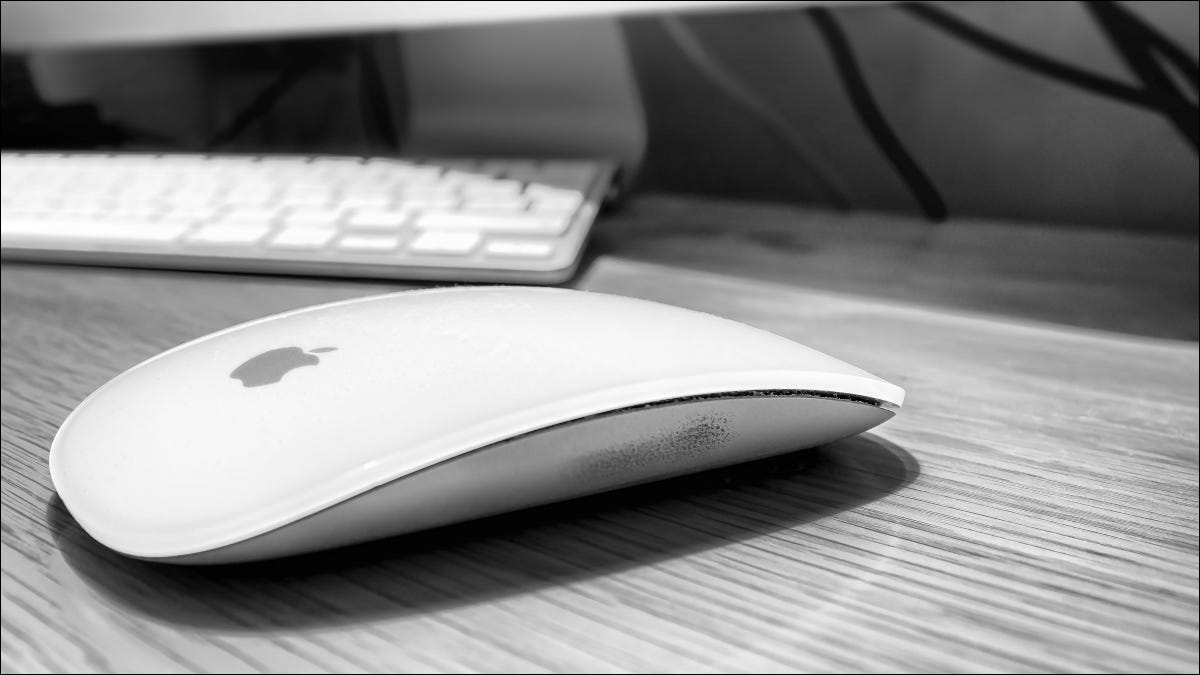 Apple Magic Mouse en un escritorio junto a un teclado.