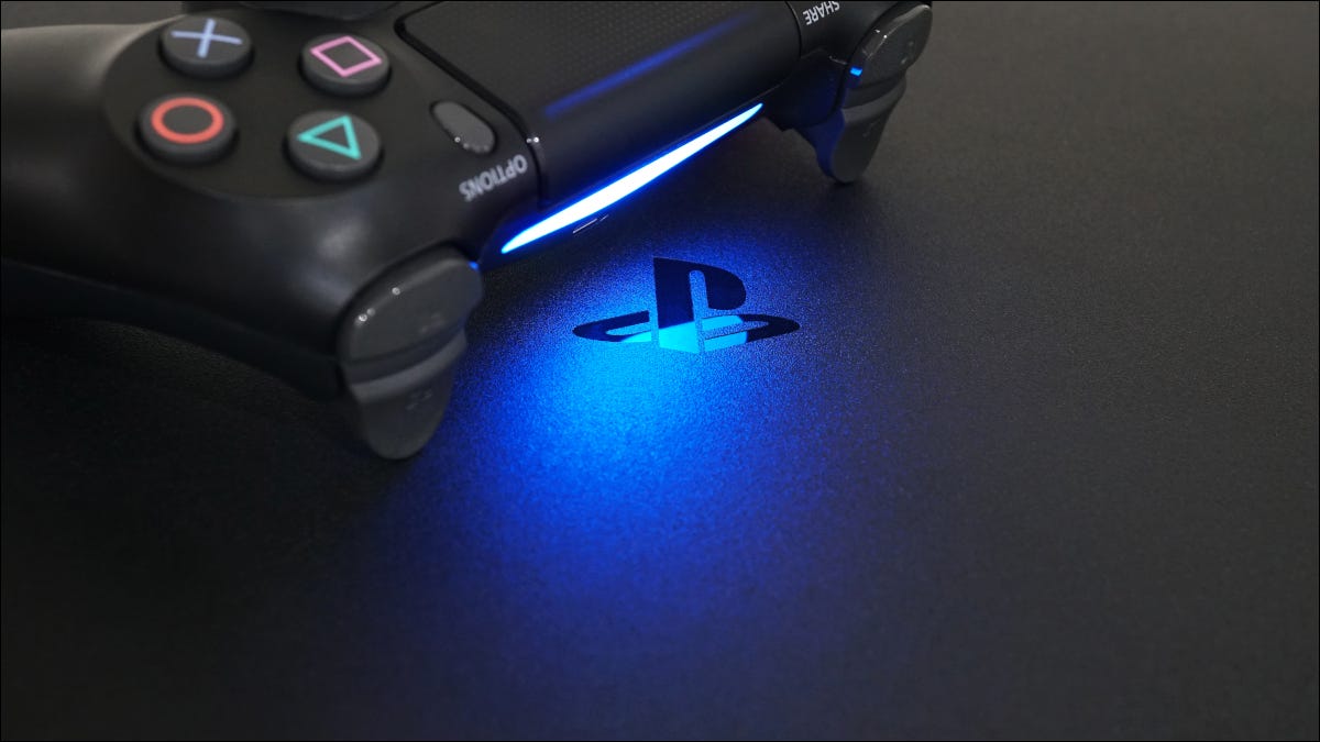 Logotipo de PlayStation en una PS4, en luz azul emitida por un controlador