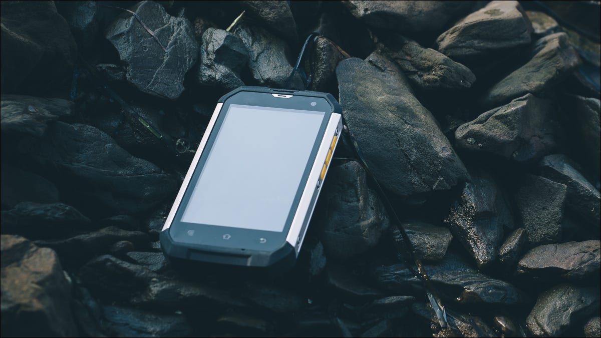 Smartphone robusto rodeado de rocas