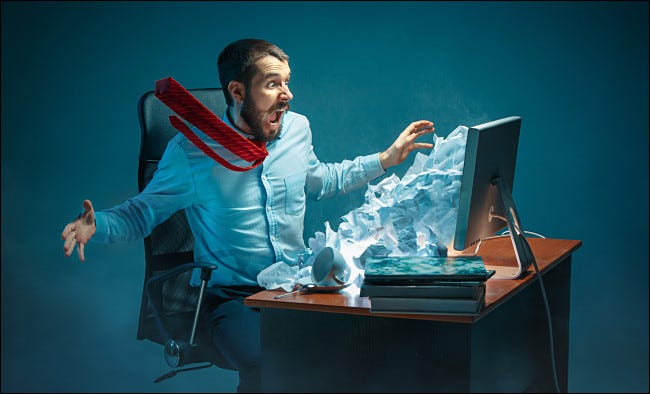 Ilustración fotográfica de un hombre reaccionando al spam procedente de su monitor.