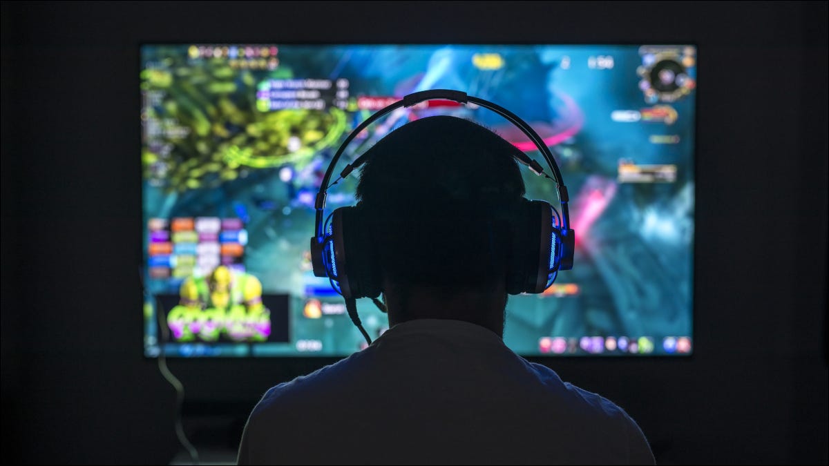 Parte posterior de la cabeza del joven jugador frente a un monitor de computadora.