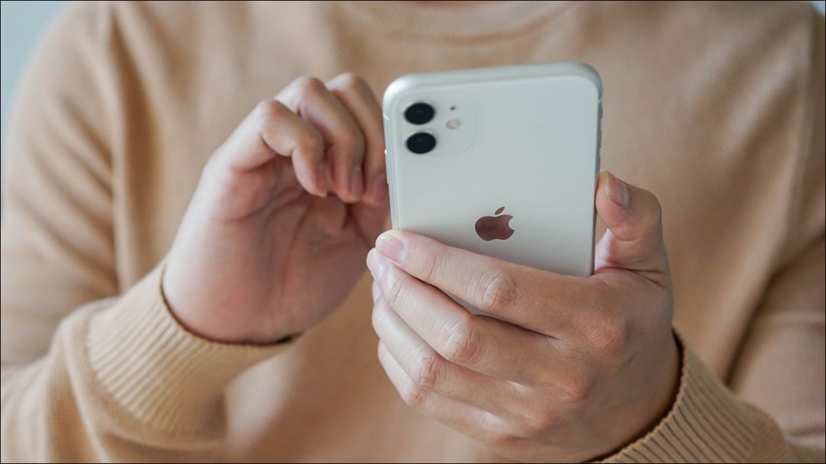 Primer plano de las manos de un hombre sosteniendo un iPhone 11.