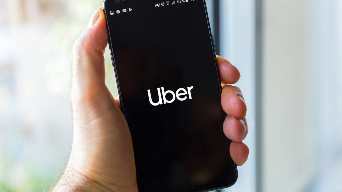 Una mano sosteniendo un teléfono inteligente que muestra el logotipo de Uber.