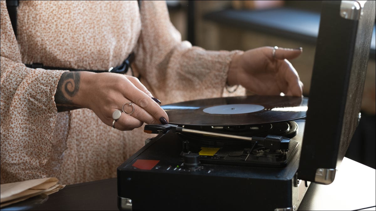 person putting vinyl on turntable