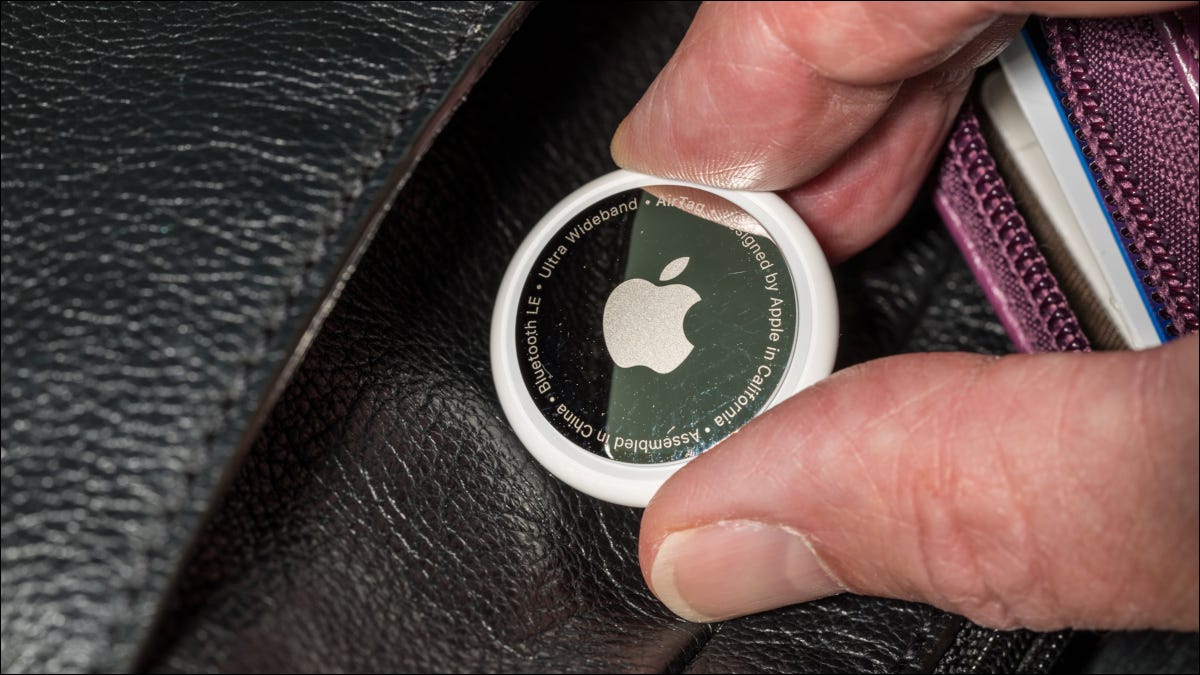 Primer plano de un Apple AirTag colocado en el bolso de cuero de alguien.